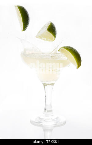 Margarita cocktail splash with limes falling inside isolated on white background Stock Photo