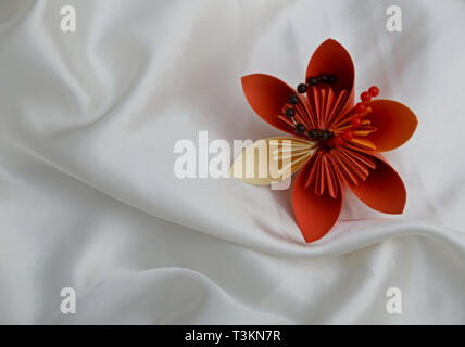 Self made beautiful and decorative  paper flowers with pearls on a satin background Stock Photo