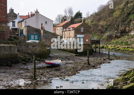 Cottages and rowing boat in Staithes Beck, Staithes, a traditional fishing village and seaside resort on the North Yorkshire coast, England UK. Stock Photo