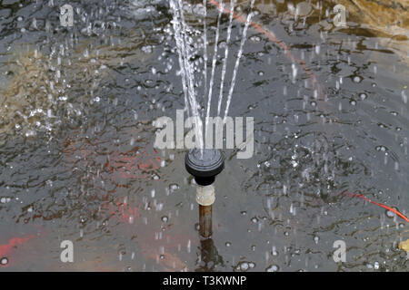 Artificial fountain in the small garden pond Stock Photo