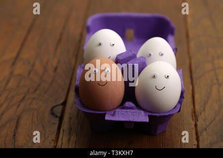 Chicken eggs with painted faces are in the box. Stock Photo