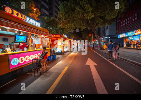 Fuzhou City, China - April 05, 2019 : Famous DaMing Lu  night food street in Fuzhou. Crowded people enjoy the traditional chinese food here at night. Stock Photo