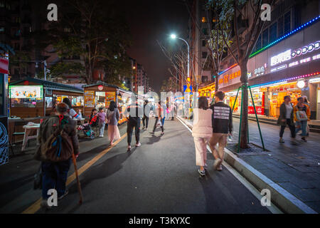 Fuzhou City, China - April 05, 2019 : Famous DaMing Lu  night food street in Fuzhou. Crowded people enjoy the traditional chinese food here at night. Stock Photo