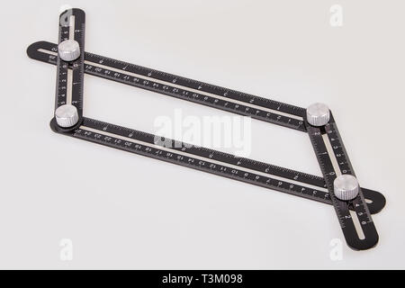 Black multi function Ruler isolated on white background. Ultimate Irregular Shape Copy Tool. Universal Easy Angle Ruler. Multi Angle Measuring Tool. Stock Photo