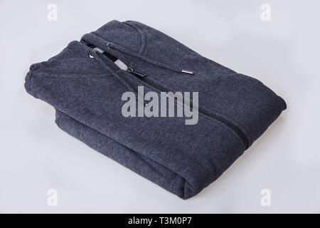 Gray folded zipped sweater with blank tag on white background. Clothes, fashion concept. Sportswear Stock Photo