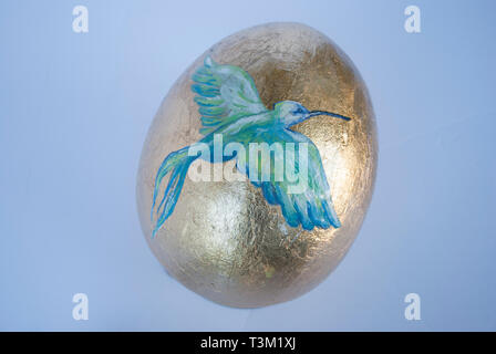 Golden Easter egg with the bird painted Stock Photo