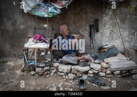 Cobbler waiting for business on the road between Patan and Kathmandu, Nepal Stock Photo