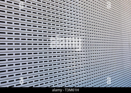 Repetitive pierced rectangular pattern on steel panel, photographed with perspective angle.  Good for industrial or modern artistic background. Stock Photo