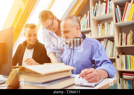 Adults learn together for further education in the library Stock Photo