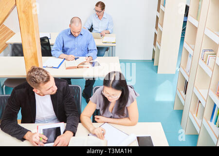 Students in a library or seminar are reading and learning together Stock Photo