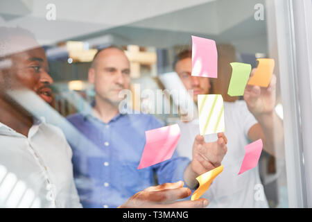 Creative brainstorming by Startup Business Team with sticky notes on glass Stock Photo