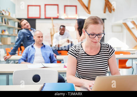 Woman as a student in a seminar for further education works on laptop computer Stock Photo