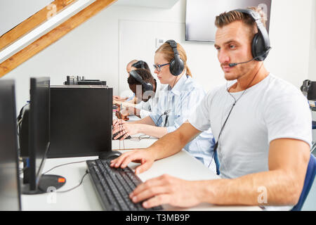 People using a headset as a member of a business hotline or as a student in a language course Stock Photo
