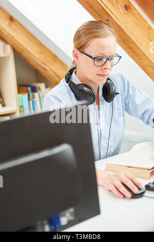Young woman as a student reading the book for further education in the library Stock Photo
