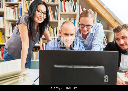 Creative start-up team works together on the PC as a software developer or designer Stock Photo
