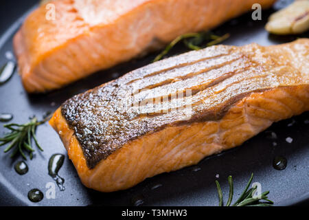Grilled Salmon Fillets in Frying Pan with Thyme and Garlic Stock Photo