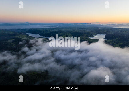 A beautiful sunrise illuminates the hills surrounding San Francisco Bay in Northern California. This area is often covered by a thick marine layer. Stock Photo