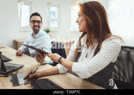 Young successful engineers colleagues talking while working on a new project in the office. Stock Photo