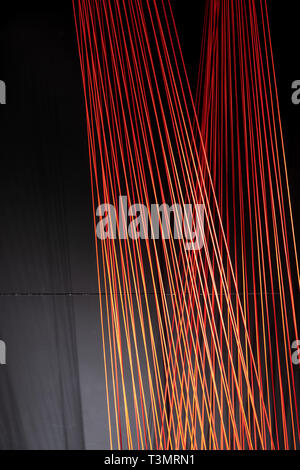 Multicolored ropes lines installation in illuminated interior Stock Photo