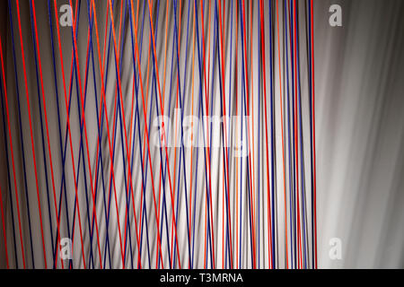Multicolored ropes lines installation in illuminated interior Stock Photo
