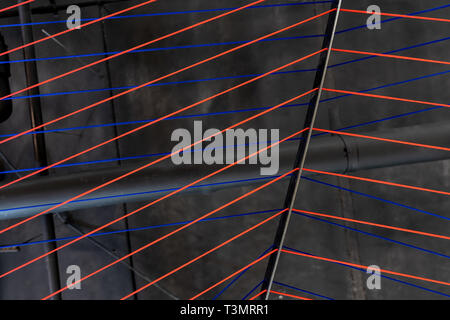 Multicolored ropes lines installation in illuminated interior Stock Photo