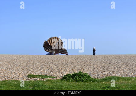 Man approaches The Scallop, Maggi Hambling's steel shell sculpture on Aldeburgh beach, Aldeburgh, Suffolk Stock Photo