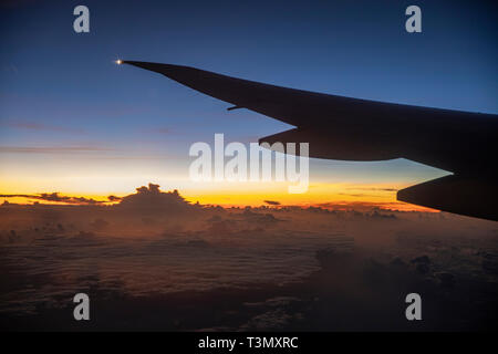 View from beautiful large tinted window of Qantas Boeing 787 dreamliner flying above the clouds approaching Sydney on direct flight from LAX Stock Photo