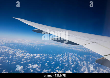 View from beautiful large tinted window of Qantas Boeing 787 dreamliner flying above the clouds approaching Sydney on direct flight from LAX Stock Photo