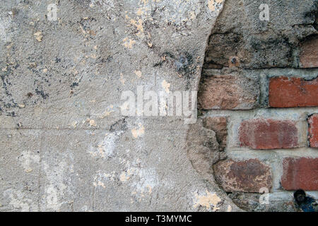 close up of cement patch over weathered red brick wall Stock Photo
