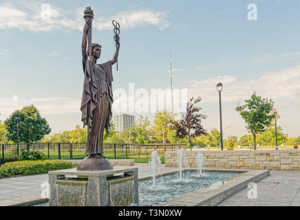 Kansas City, MO - August 20, 2014: This 12 foot bronze figure titled The Spirit of Commerce created by Tuck Langland is in front of the Federal Reserv Stock Photo