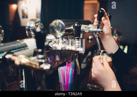 Mans hand pouring pint of beer behind the bar Stock Photo