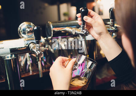 Mans hand pouring pint of beer behind the bar Stock Photo