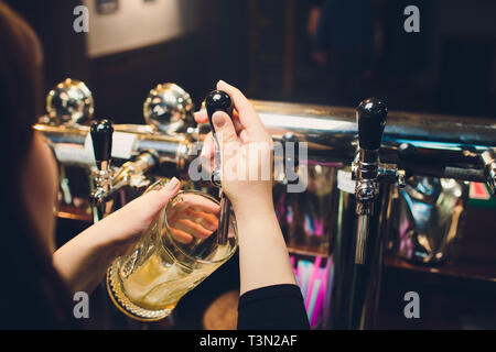 Mans hand pouring pint of beer behind the bar Stock Photo