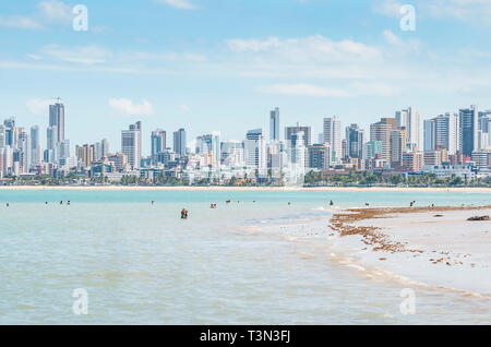 Local people and tourists at Praia do Bessa beach, Joao Pessoa PB, Brazil. Beachfront buildings on background. Stock Photo