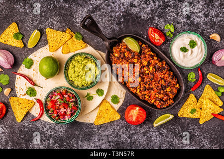 Mexican food concept: tortillas, nachos with guacamole, salsa, chili con carne, top view. Stock Photo