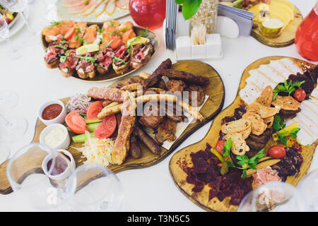 Assorted delicious grilled meat with vegetable on white plate on picnic table for family bbq party Stock Photo