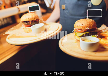 Hamburgers and French fries on the wooden tray Stock Photo