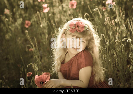 beautiful blond girl in red corn poppy field sepia toned Stock Photo
