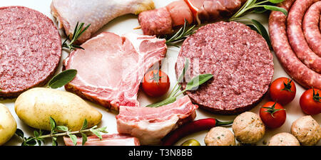 banner of different types of raw meat: chicken thighs, pork and beef burgers, ribs and kebabs, turkey meatballs, ready to be cooked with potatoes, hot Stock Photo