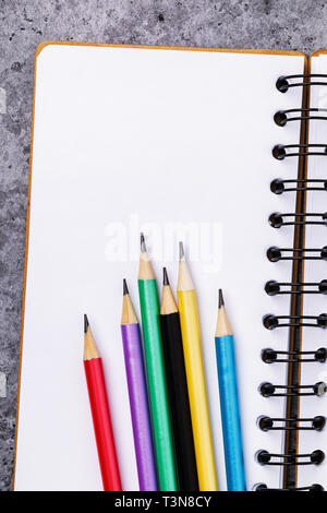 Pencils on a notebook with copy space, top view Stock Photo