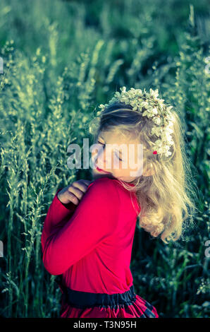 beautiful blond girl sitting with closed eyes in flower meadow Stock ...