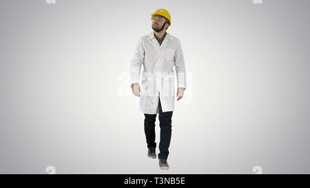 Engineer putting on protactive glasses while walking on gradient background. Stock Photo