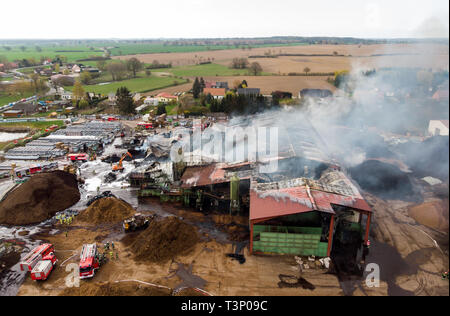 Roggendorf, Germany. 11th Apr, 2019. Firefighters extinguish a major fire in a peat factory (recording with drone). Several warehouses and production halls have gone up in flames there. Credit: Daniel Bockwoldt/dpa/Alamy Live News Stock Photo