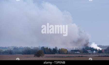 Roggendorf, Germany. 11th Apr, 2019. A column of smoke crosses the village during a major fire in a peat factory. Several warehouses and production halls have gone up in flames there. Credit: Daniel Bockwoldt/dpa/Alamy Live News Stock Photo