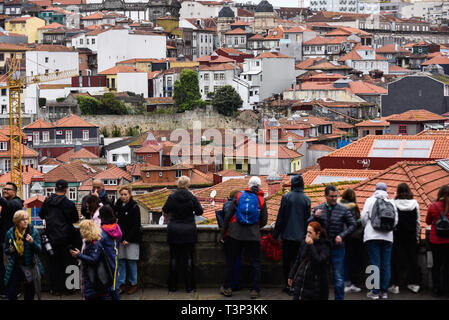 Porto, Portugal. 7th Apr, 2019. Tourists are seen at Se do Porto view point. In 2018, Porto entered the list of the 100 most visited cities in the world in a ranking prepared by Euromonitor International. In 2018 it is estimated that the number of tourists reached 2.39 million. Credit: Omar Marques/SOPA Images/ZUMA Wire/Alamy Live News Stock Photo