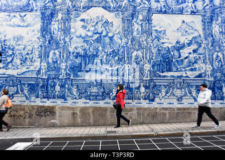 Porto, Portugal. 7th Apr, 2019. People seen walking by a blue mosaic next to Bolhao Market. In 2018, Porto entered the list of the 100 most visited cities in the world in a ranking prepared by Euromonitor International. In 2018 it is estimated that the number of tourists reached 2.39 million. Credit: Omar Marques/SOPA Images/ZUMA Wire/Alamy Live News Stock Photo