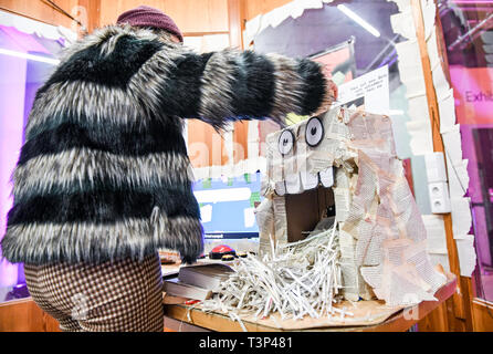 Berlin, Germany. 11th Apr, 2019. At the Games and Playful Media Festival 'A Maze' at the SEZ, a woman is working on the computer game 'The Book Ritual' as part of Gamesweekberlin 2019, in which texts are changed and real book pages are shredded. The international network meeting of the games industry will take place from 08.04. to 14.04.2019. Credit: Jens Kalaene/dpa-Zentralbild/dpa/Alamy Live News Stock Photo