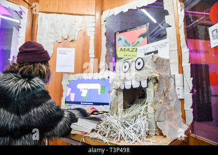 Berlin, Germany. 11th Apr, 2019. At the Games and Playful Media Festival 'A Maze' at the SEZ, a woman is working on the computer game 'The Book Ritual' as part of Gamesweekberlin 2019, in which texts are changed and real book pages are shredded. The international network meeting of the games industry will take place from 08.04. to 14.04.2019. Credit: Jens Kalaene/dpa-Zentralbild/dpa/Alamy Live News Stock Photo