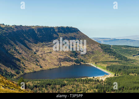 Craig y Llyn cliffs rising above Llyn Fawr, the big lake at the top of the Dare Valley in south Wales as seen from the Rhigos mountain pass. Stock Photo