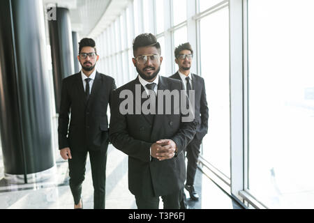 Portrait of three happy success handsome business man walk and talk. Teamwork friendship. Stock Photo
